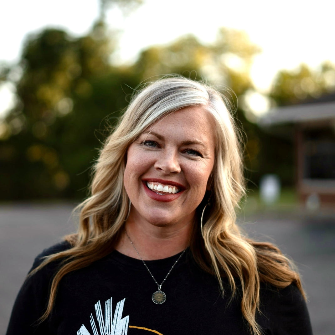 Courtney Patton smiling outdoors with trees in the background